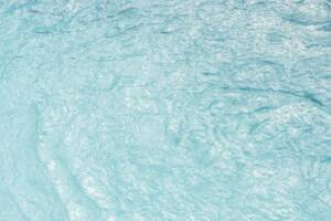 Swimming pool water texture in sunlight background